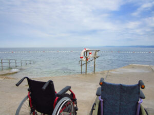 Representación de turismo accesible con una foto de sillas de ruedas mirando el mar
