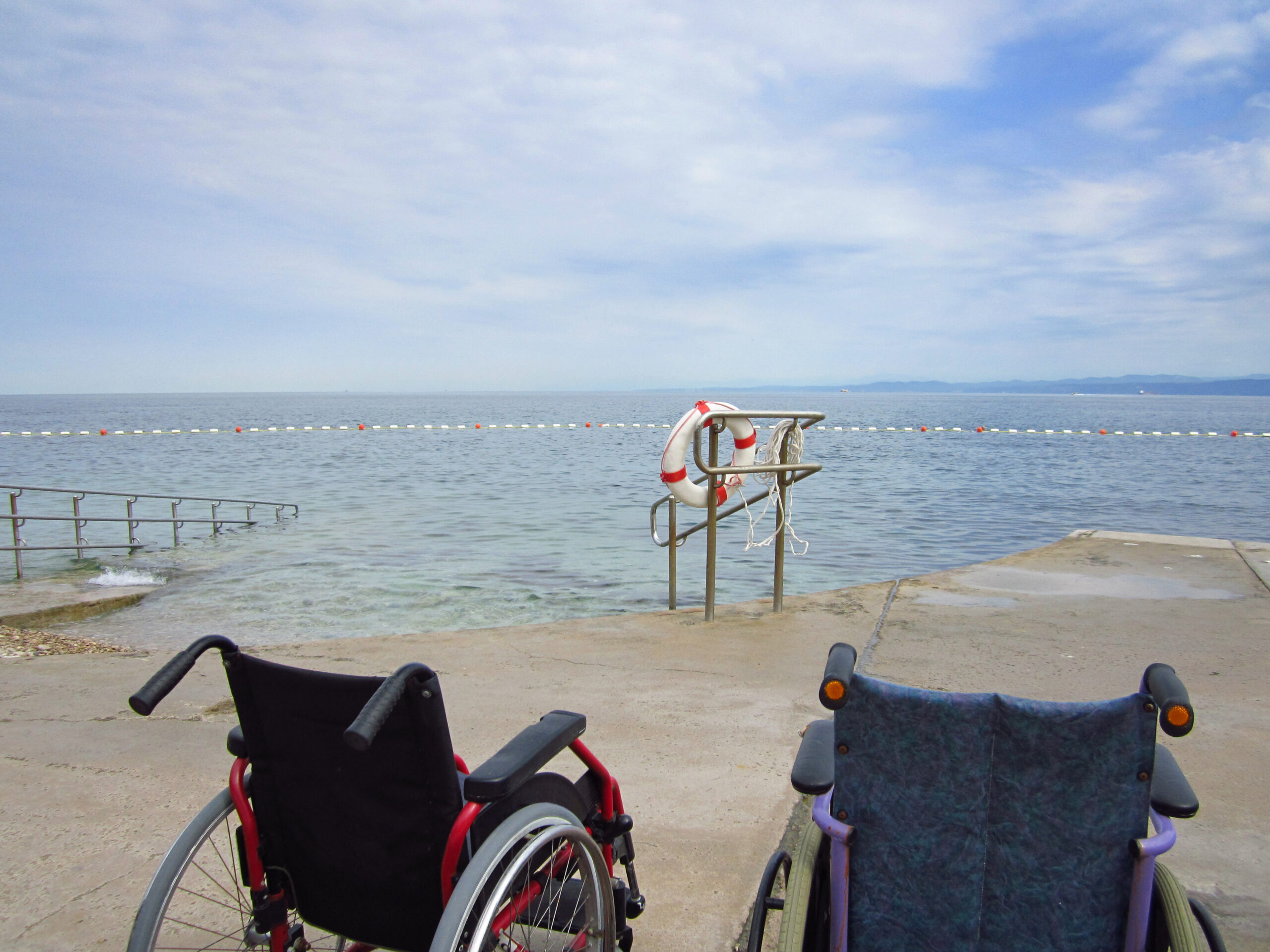 Representación de turismo accesible con una foto de sillas de ruedas mirando el mar