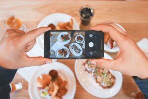 Imagen de un teléfono móvil sacando una foto a comida