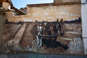 Mural de dos burros arando, pintado en tonos ocre