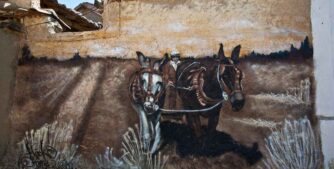 Mural de dos burros arando, pintado en tonos ocre