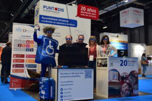 Equipo de puntodis posando con gafas de baja visión en el stand de puntodis en Fitur 2024