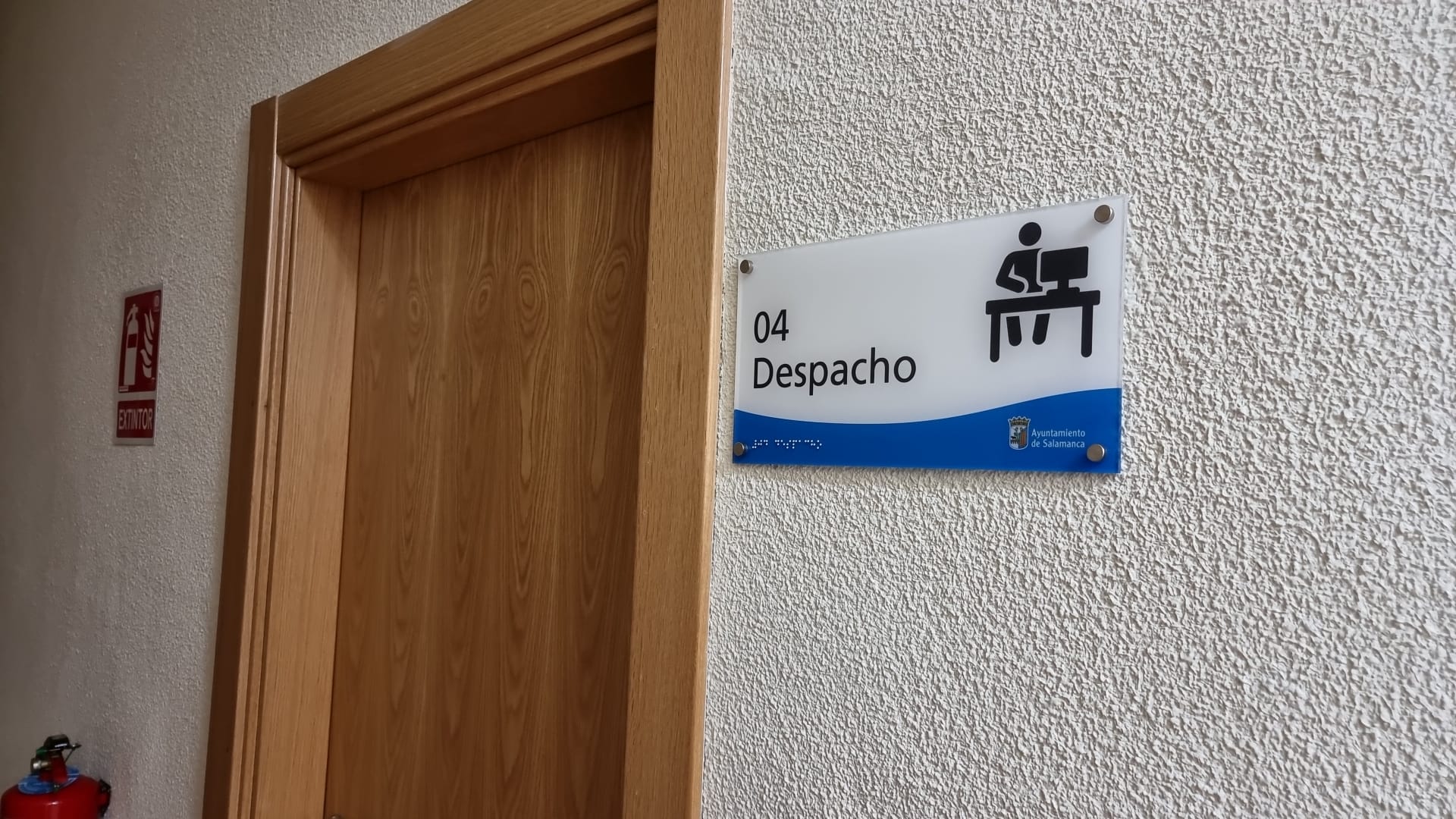 Señal colocada en pared con el texto "despacho" y pictograma que hace referencia al mismo