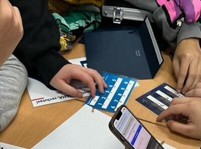 Grupo de estudiantes de secundaria resolviendo el reto con tarjetas en braille y soporte digital durante la actividad gamificada de Element106.