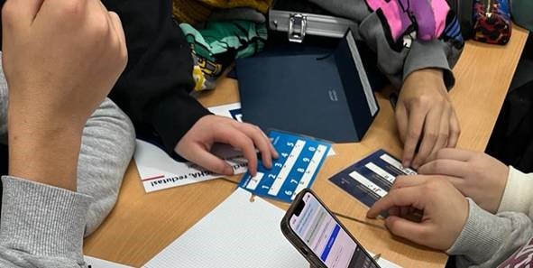 Grupo de estudiantes de secundaria resolviendo el reto con tarjetas en braille y soporte digital durante la actividad gamificada de Element106.