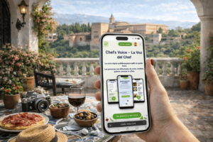 Mano sosteniendo un smartphone que muestra la web de Chef’s Voice, con la carta digital audible y accesible para restaurantes.