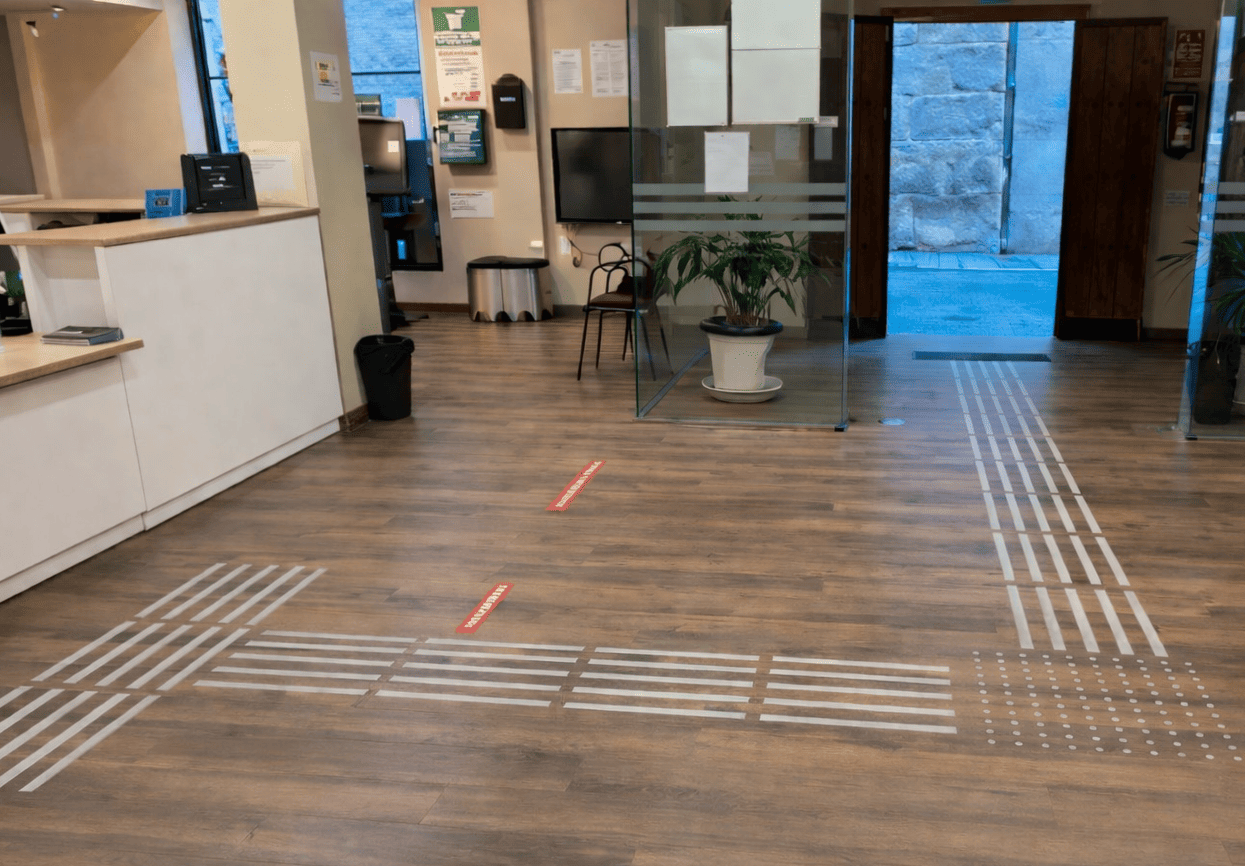 Suelo tactovisual en la Oficina de Turismo de Antequera, con franjas en relieve que guían a las personas por el espacio de forma autónoma.