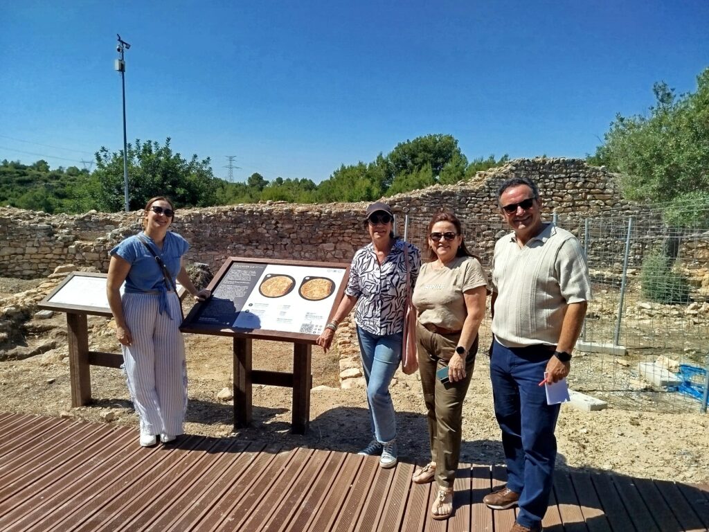 Jon Ibarra, CEO de Puntodis, con el equipo de Riba-roja de Túria y los responsables del proyecto durante la visita al yacimiento arqueológico, frente a uno de los nuevos paneles informativos accesibles.